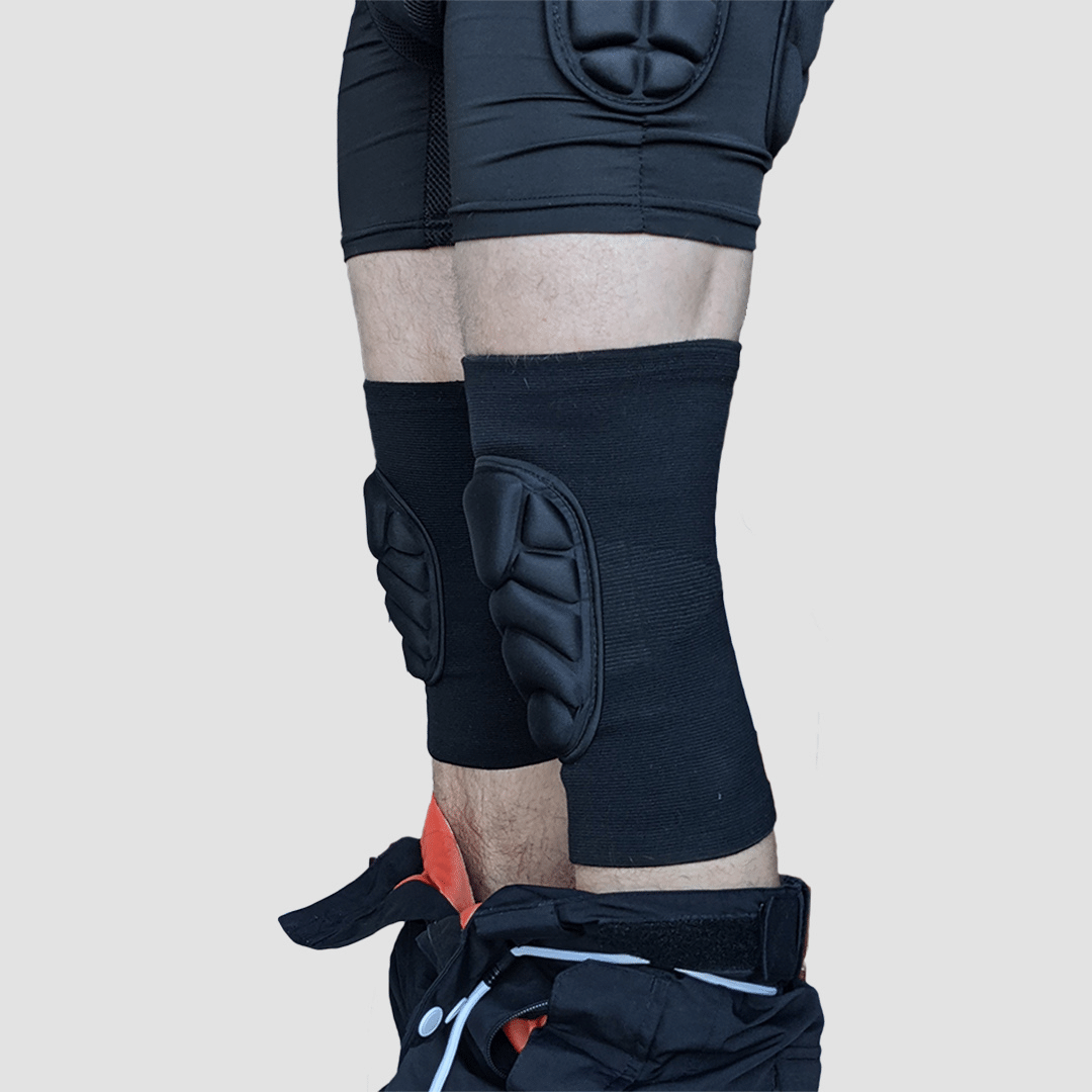 Side view of snowboarder wearing protective padded knee pads